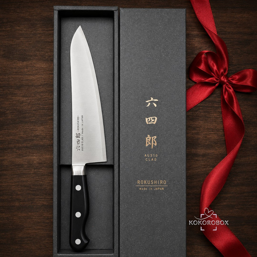 Cuchillo de chef japonés Gyuto Kokorobox de 180mm en acero AUS-10 dentro de una caja de regalo negra con lazo rojo.