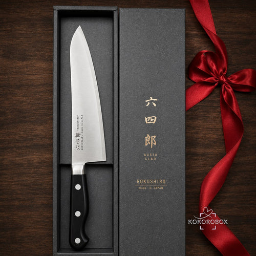 Cuchillo de chef japonés Gyuto Kokorobox de 180mm en acero AUS-10 dentro de una caja de regalo negra con lazo rojo.